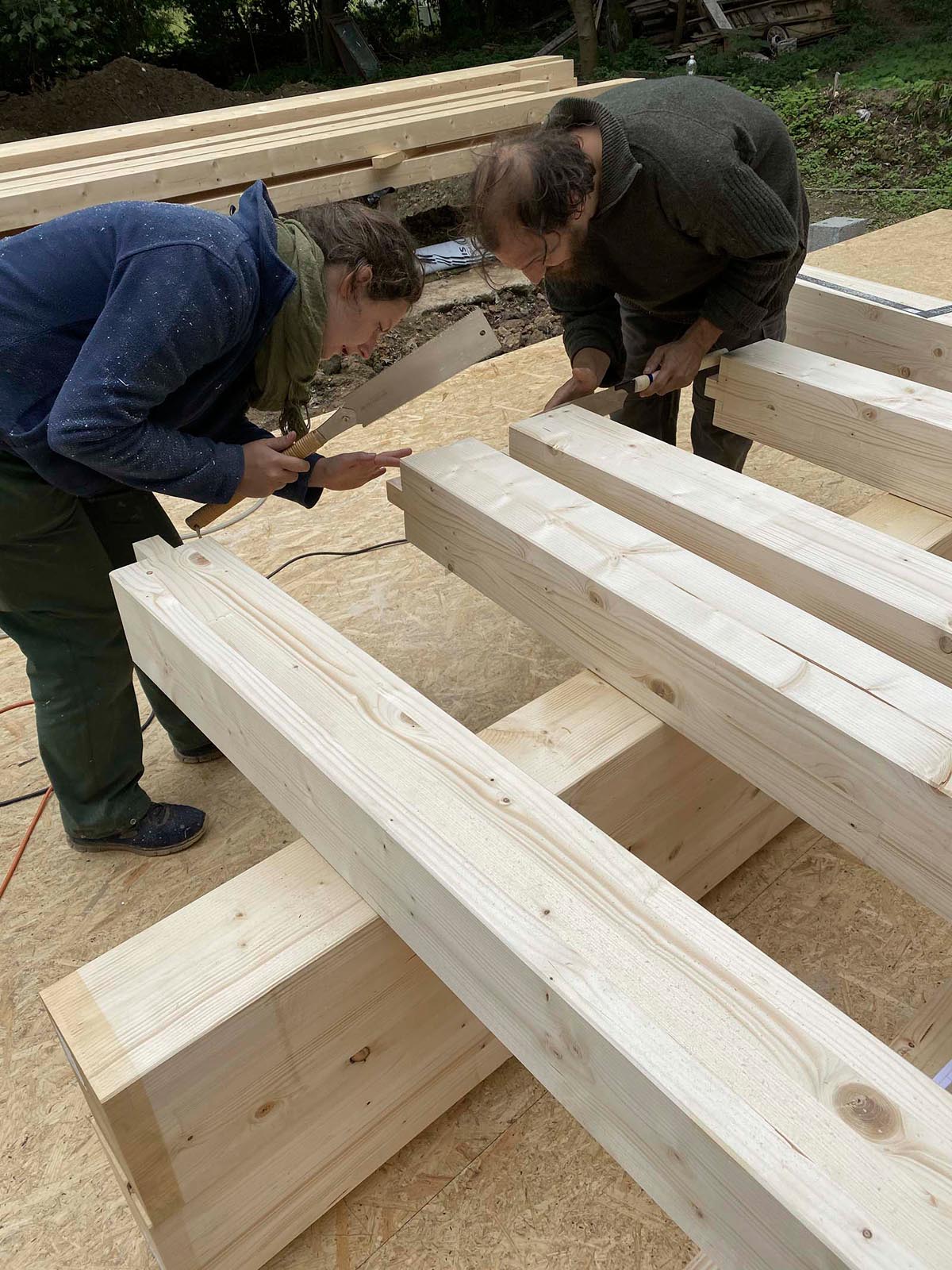 Holzskeletthaus - schnitzen der Zapfen für das erste Portalgestell Holzskeletthaus - schnitzen der Zapfen für das erste Portalgestell